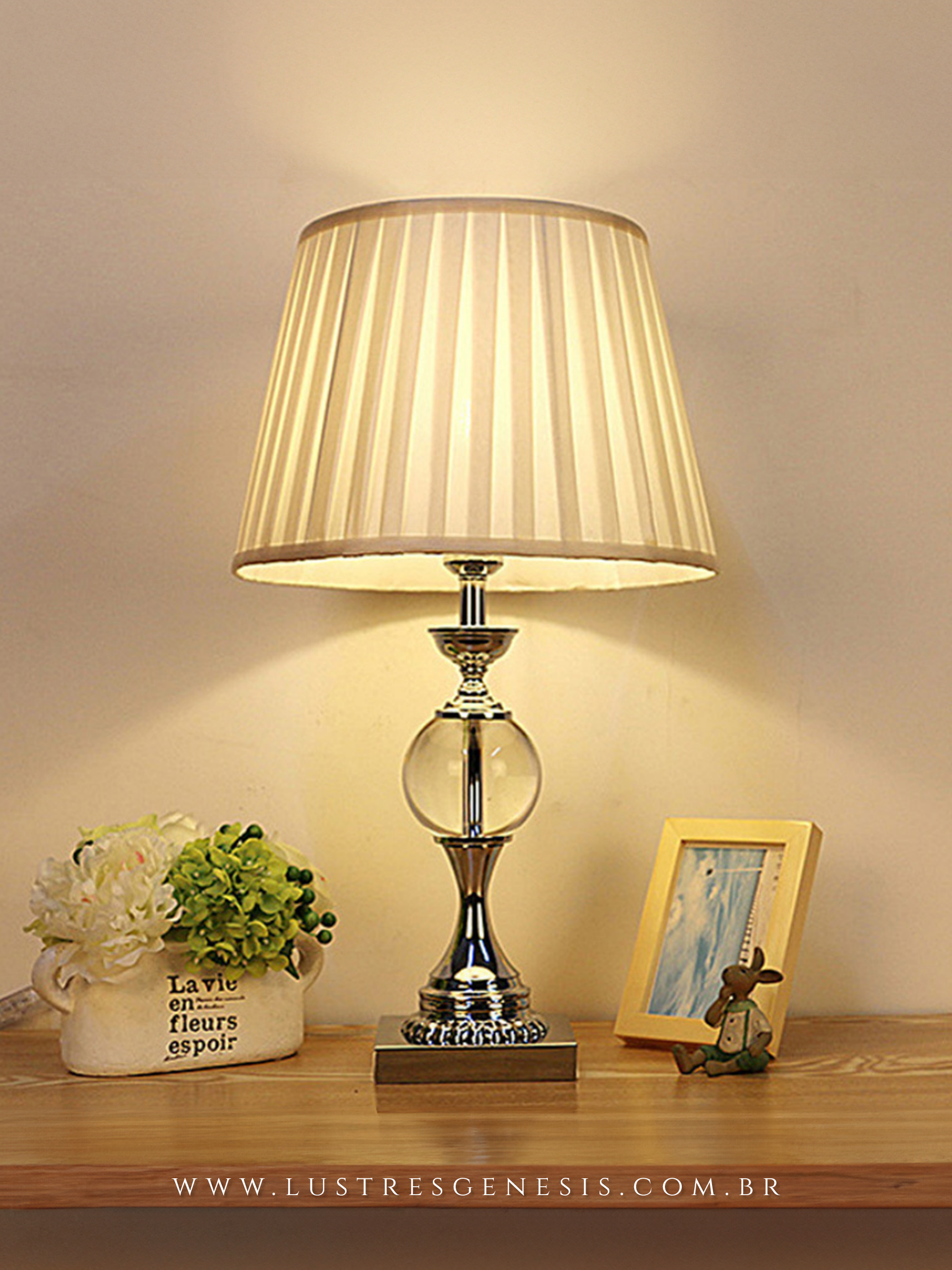 Abajur Riano com base cromada e cúpula bege, ideal para cabeceira de cama ou mesa de escritório, da marca Lux Lustres.